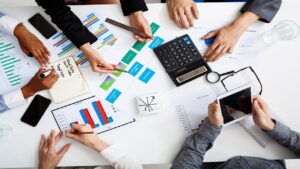 picture of businessmen's hands on white table with documents and drafts